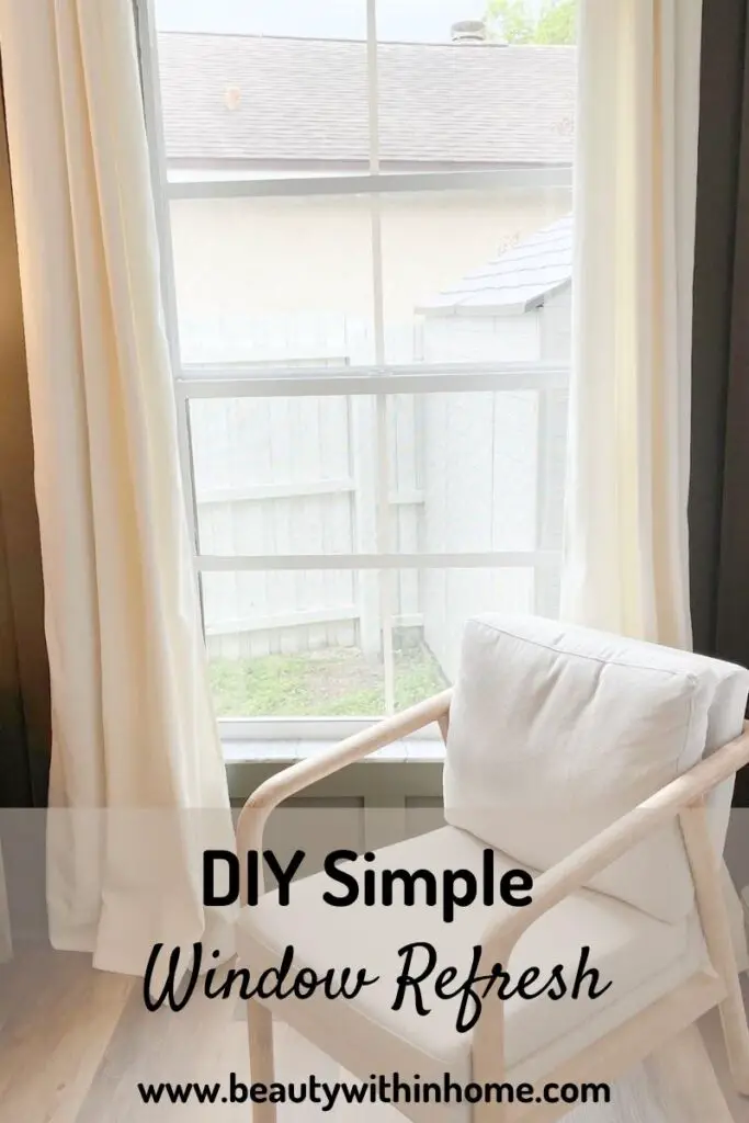 Window with white trim and white grids with ivory curtains and a green wall and an ivory chair in front of the window