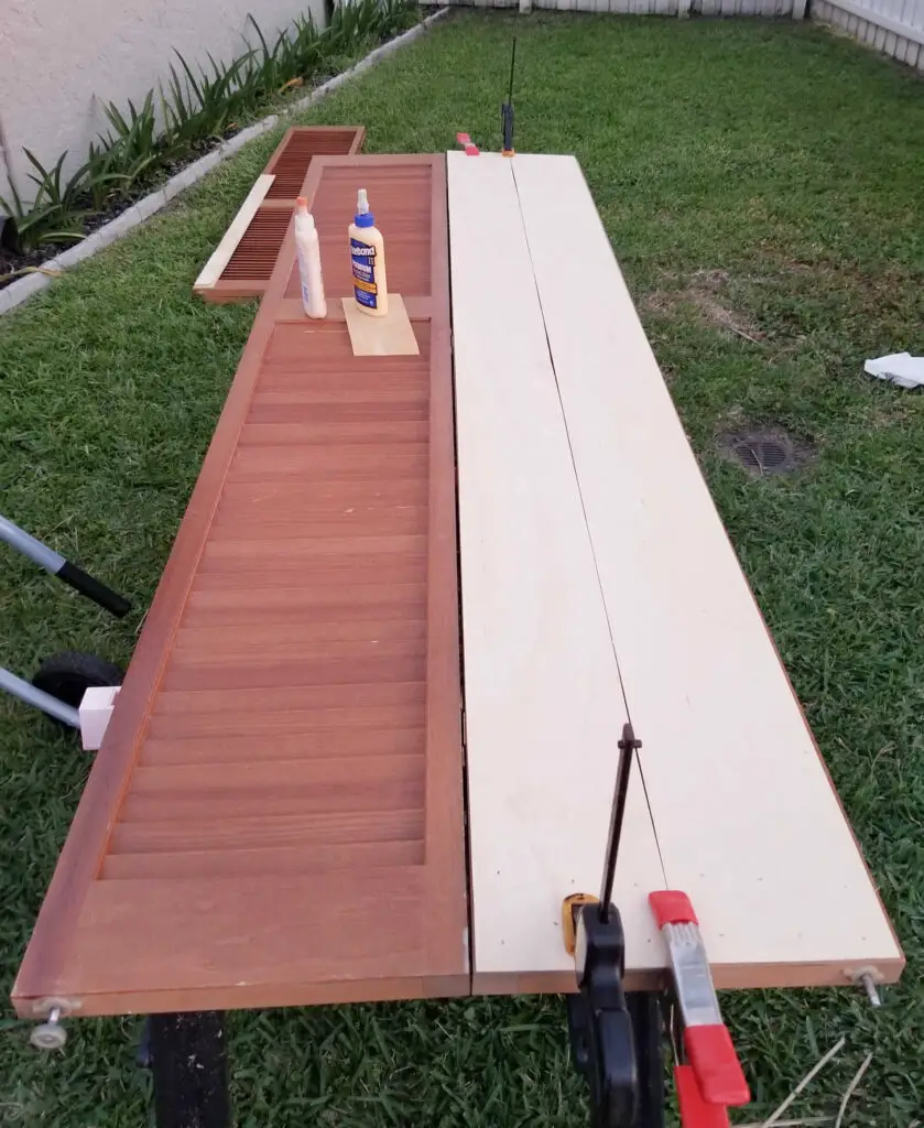 wood bifold closet door with wood glue and clamps and thin underlayment wood slats being secured to one side