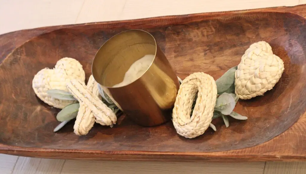 wood sourdough bowl with a gold candle and xo and hearts in ivory and greenery