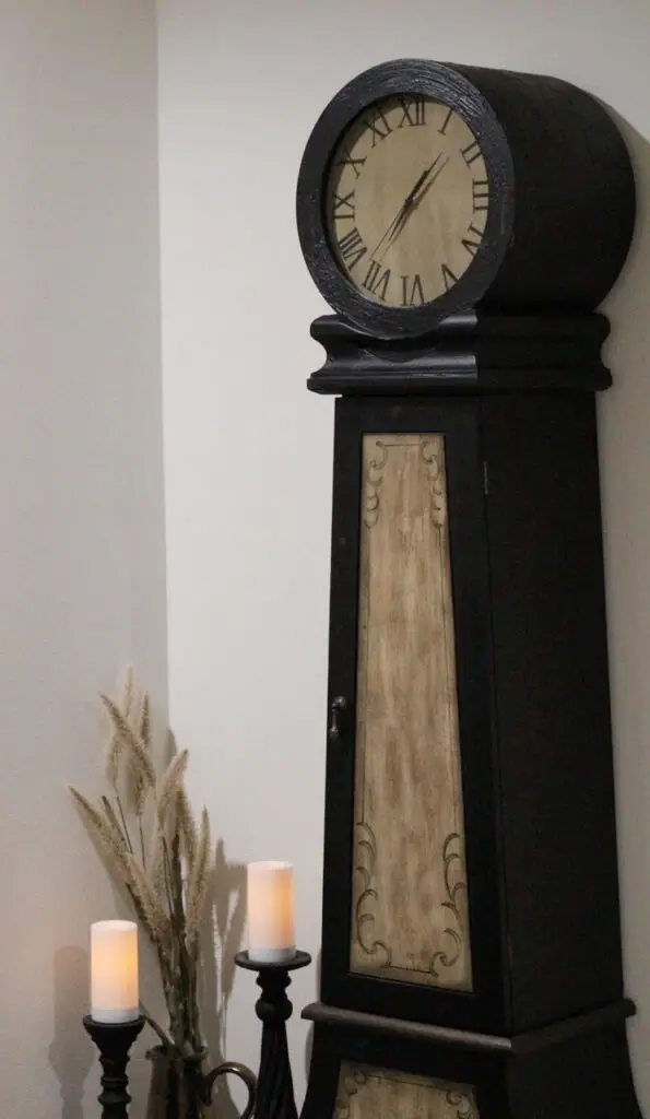 black clock with fake candles and fake plant in vase in a farmhouse family room