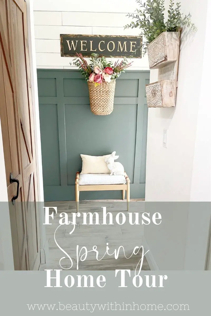 farmhouse spring home tour basket with pink spring flowers, greenery, against a green board and batten wall and white shiplap