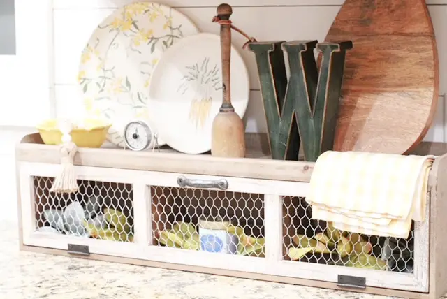 Shelf with spring plates in yellow and orange, with a wooden egg shaped cutting board and green W.