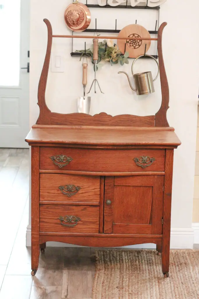 A wood antique washstand with orange stain on it 