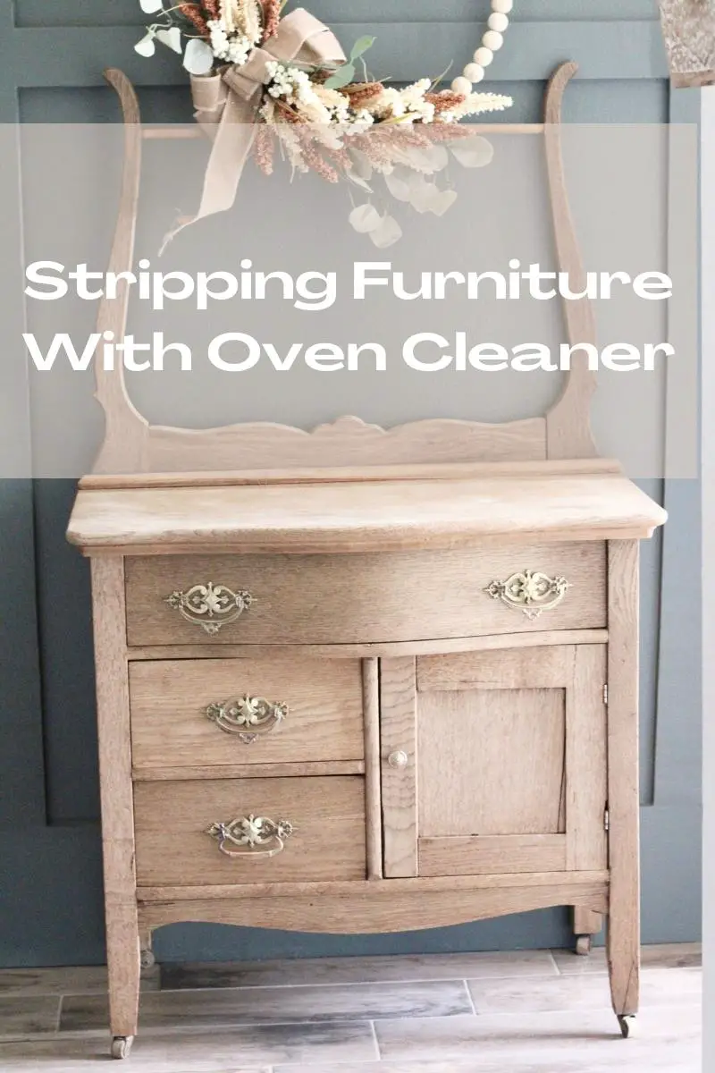 A light, natural wood washstand in front of a dark green wall with the words "Stripping Furniture With Oven Cleaner" written across it