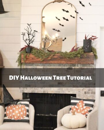 A black Halloween tree with black bats on it on a wood fireplace mantle with a gold mirror and black bats across it.