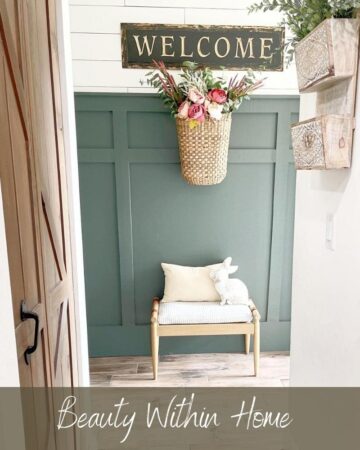 A green painted board and batten wall with white shiplap above it, a basket with pink flowers hanging on the wall and a wood bench underneath. The words "Beauty Within Home Paint Colors" is written at the bottom.