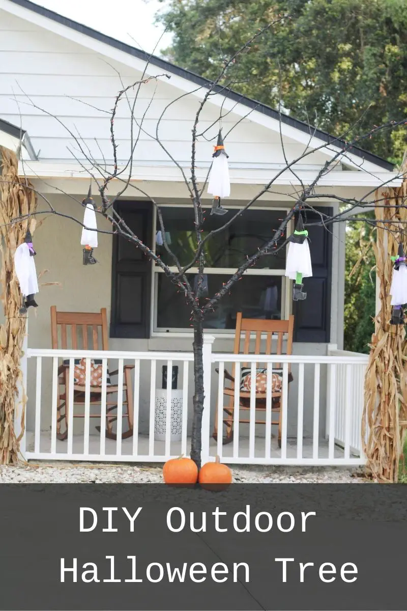 A close up of a black tree with no leaves and white ghosts hanging off of it and its in front of a grey and White House with the words DIY Outdoor Halloween Tree written on the bottom