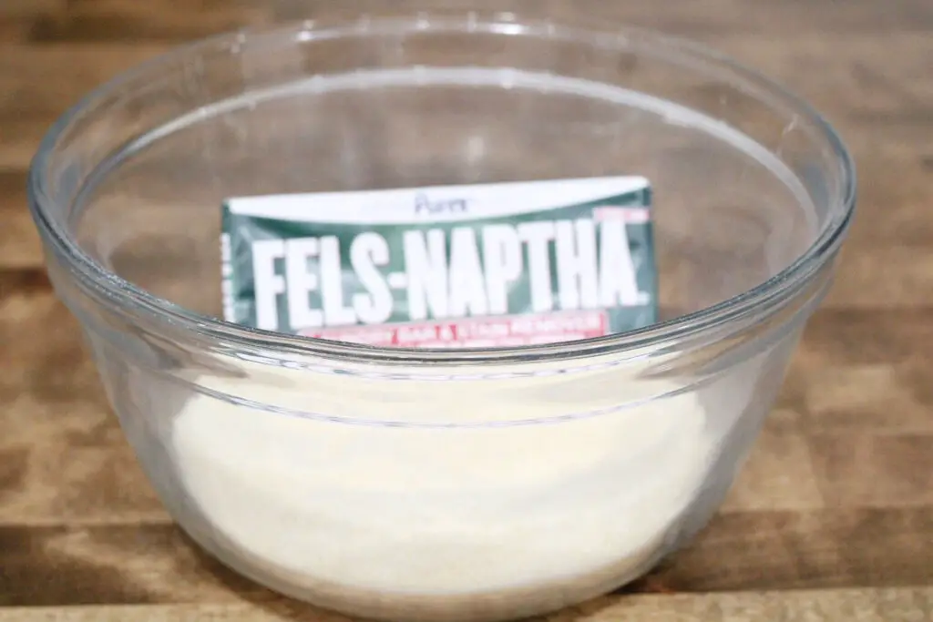close up of a glass bowl with fels-naptha bar of powder soap in it