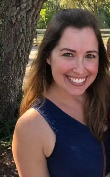 Close up of a woman with brown hair and a blue tank top on 