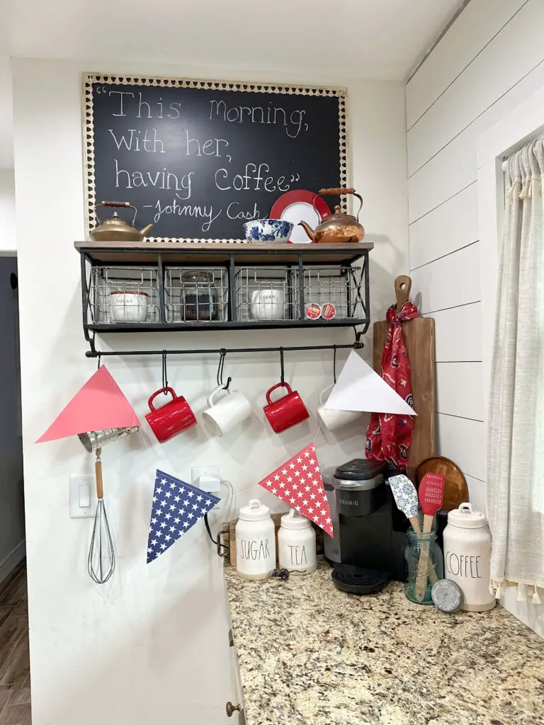 red and white mugs. glass jar with coffee. copper tea pot, red white and blue garland. Kerig machine. 