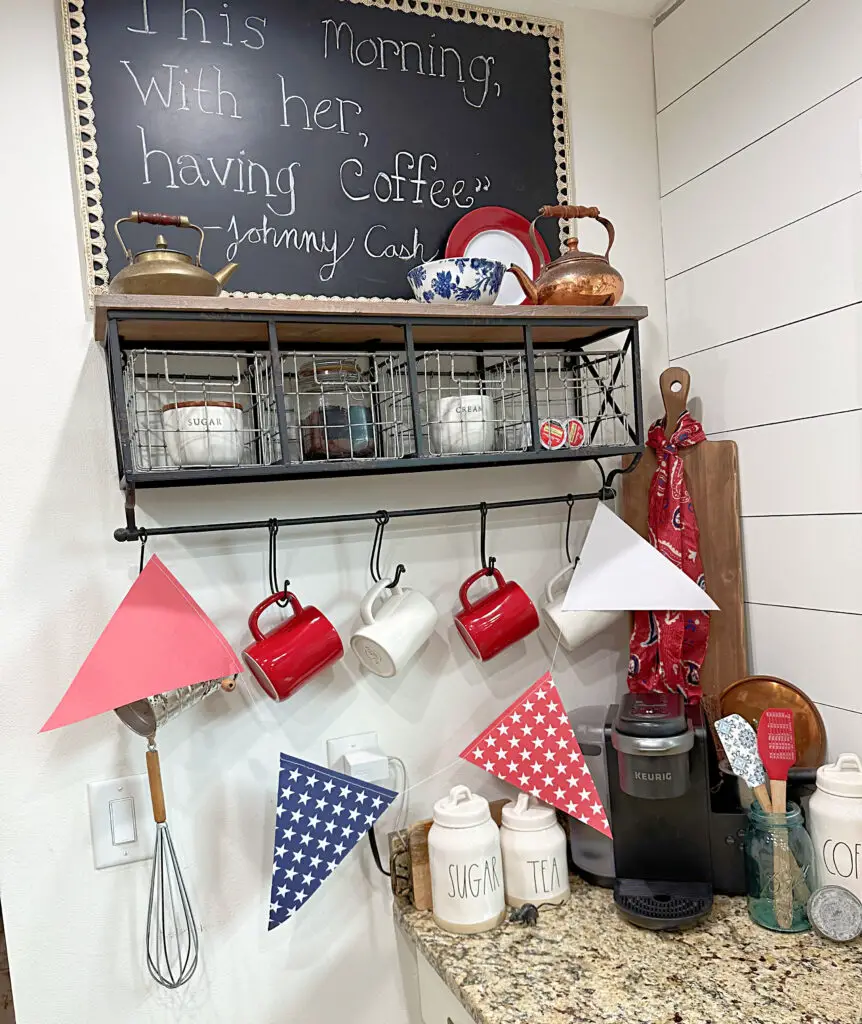 red, white, and blue triangles on a string garland, red and white mugs. coffee and coffee pods. Kerig. close up of various coffee bar decor 